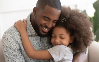 Child Maintenance Trusts. Accompanying image: loving father hugs his daughter with eyes closed
