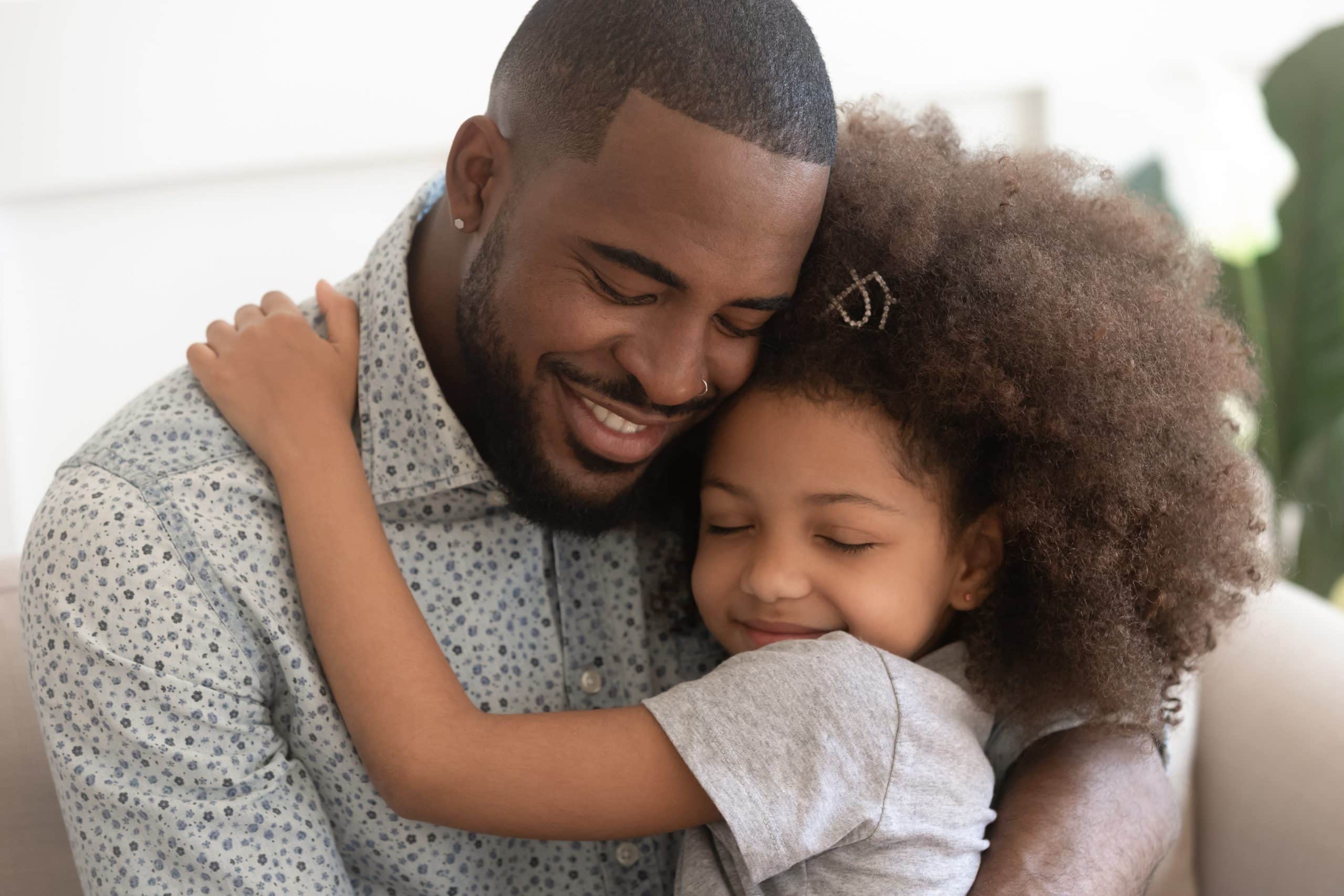 Child Maintenance Trusts. Accompanying image: loving father hugs his daughter with eyes closed