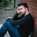 Dealing with tax debt. Accompanying picture: a sad man suffering emotional pain