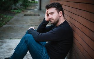 Dealing with tax debt. Accompanying picture: a sad man suffering emotional pain