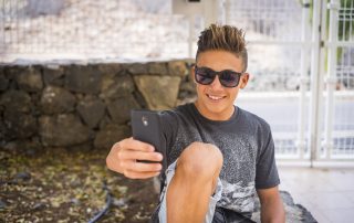 Children don't do affidavits. Accompanying image: A teenage boy takes a selfie with mobile phone smiling