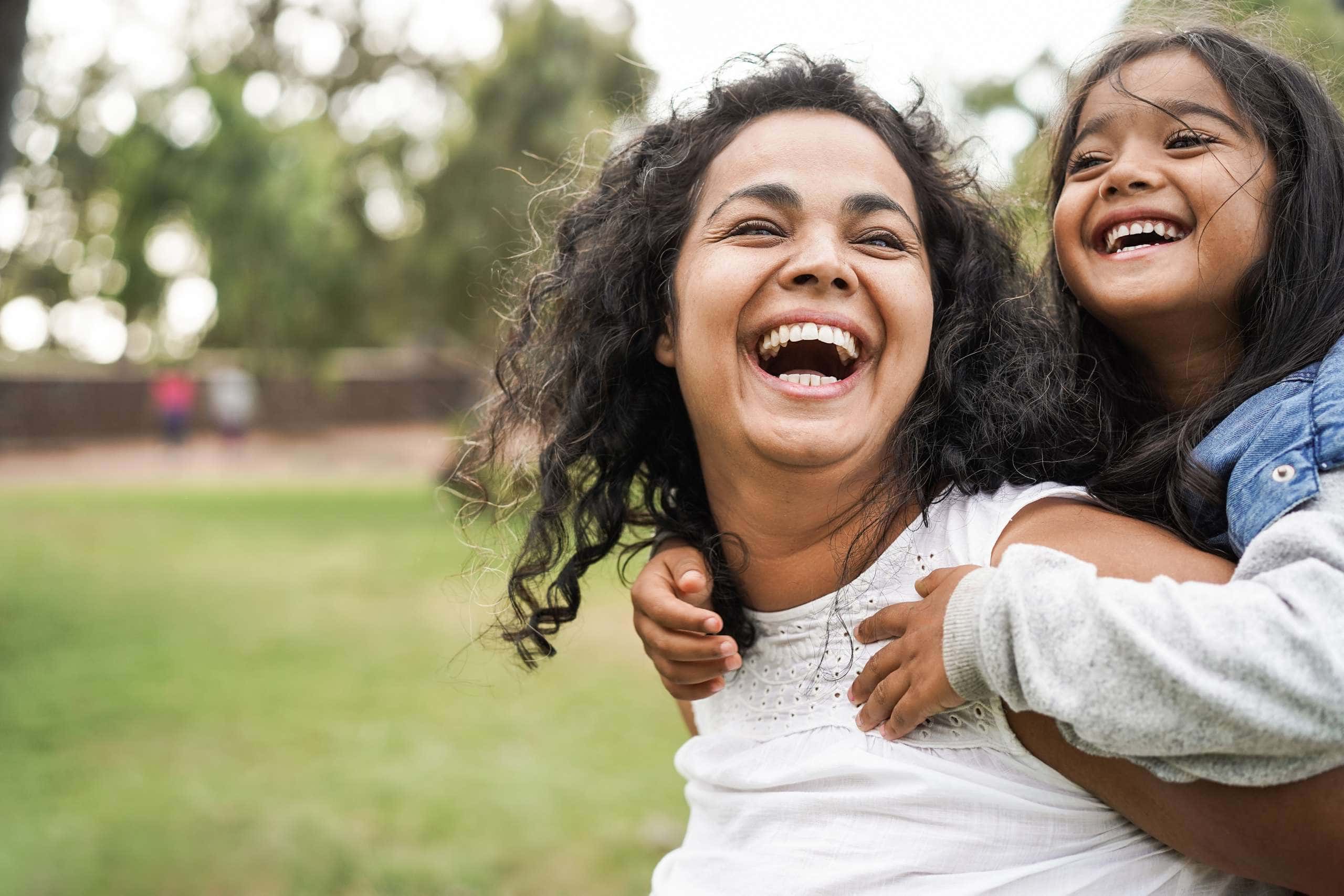 Image of mother carrying her daughter on her shoulders, accompanying family law article "Parental responsibility - navigating cultural differences