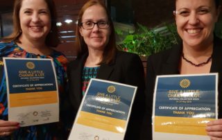 A photo of Belinda, Debra and Tarah with certificates 'Give a little change a lot"