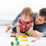 A photo of a father playing with toddler