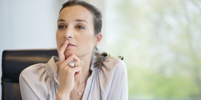 A photo a a woman thinking,. A close-up of a businesswoman thinking in an office