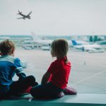 This image accompanies a family law article called "CHILD TAKEN OVERSEAS - WHAT CAN YOU DO?". The image features two children looking at airplanes at the airport.