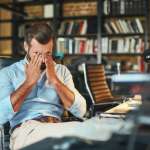 Image of an exhausted bearded businessman, accompanying family law article "How to survive separation"