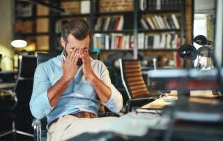 Image of an exhausted bearded businessman, accompanying family law article "How to survive separation"