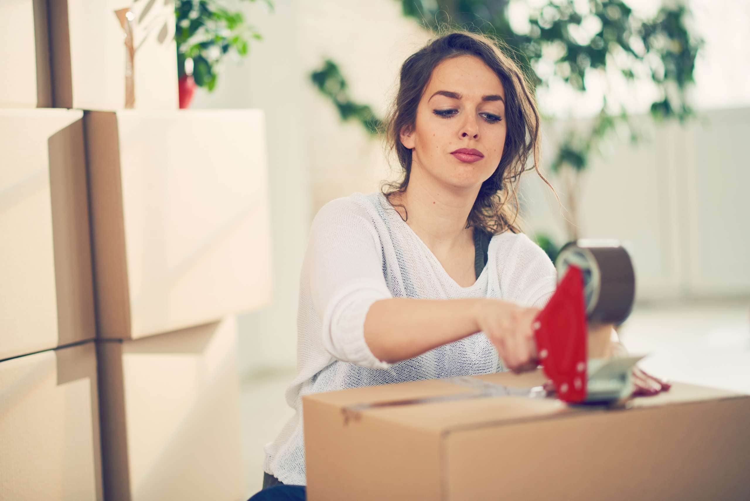 Image of a woman packing boxes, accompanying family law article "Don’t Delay Your Property Settlement"
