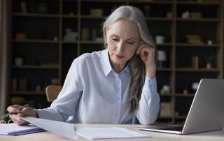 Image of busy elderly freelance business woman doing paperwork, accompanying family law article "Changing a child's surname"