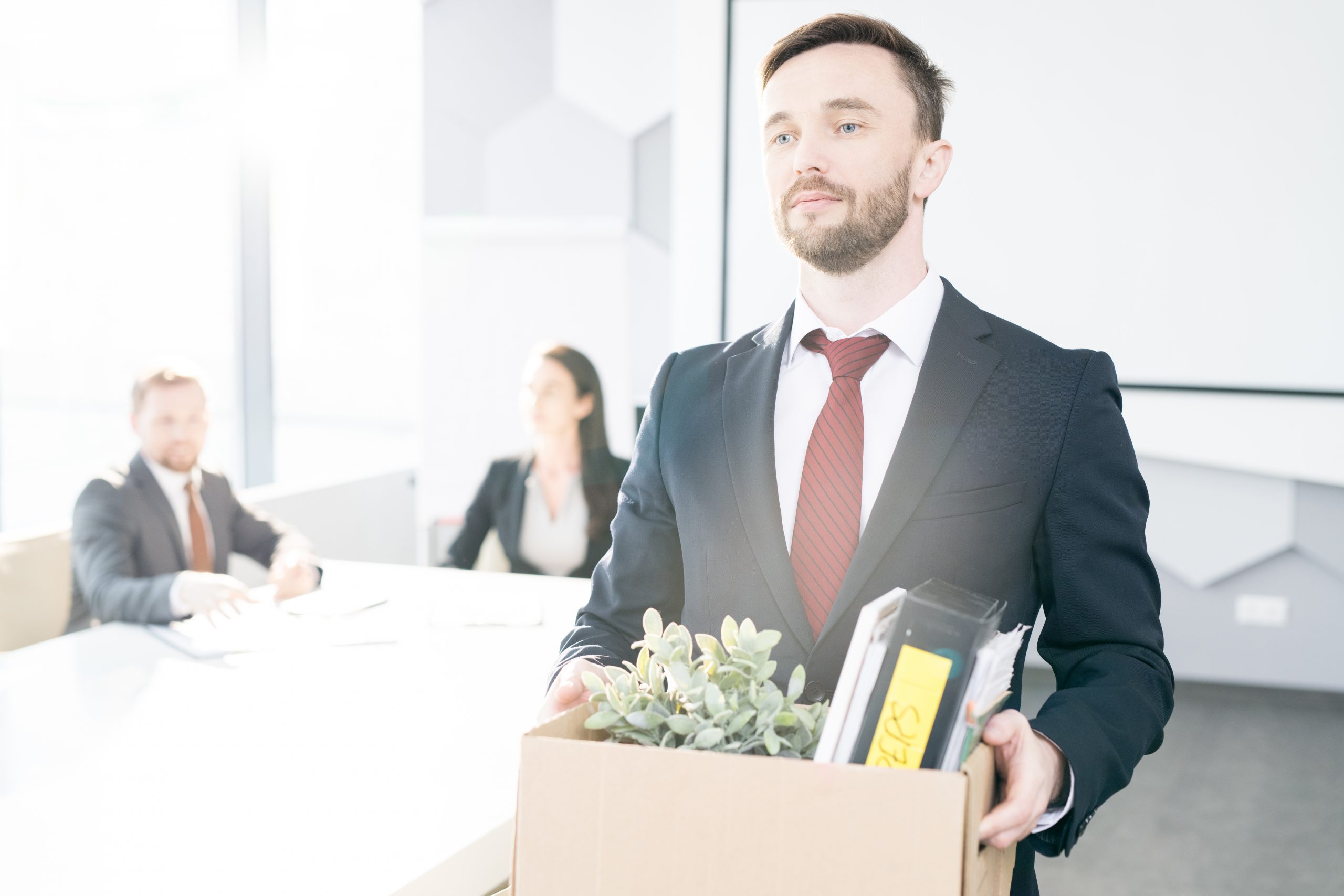 What Happens To Post-Separation Redundancy Payments? Accompanying image: portrait of man holding box of personal belongings leaving office after a redundancy