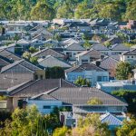 Relocation to outskirts of city after a divorce. Accompanying image: elevated view of many residential houses in suburb in Queensland, Australia.