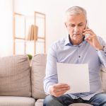 COVID-19 helpful tips if you are separated. Accompanying image: senior man talking on mobile phone holding document