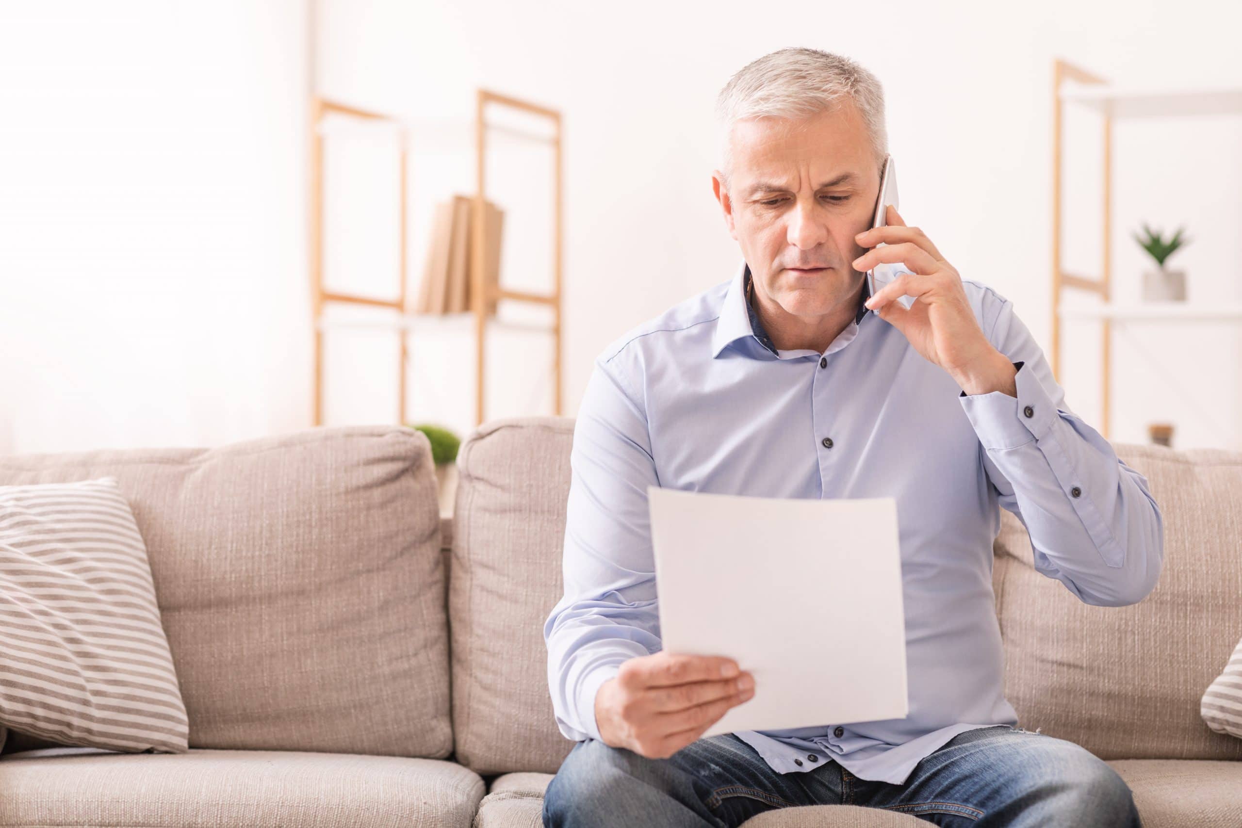 COVID-19 helpful tips if you are separated. Accompanying image: senior man talking on mobile phone holding document