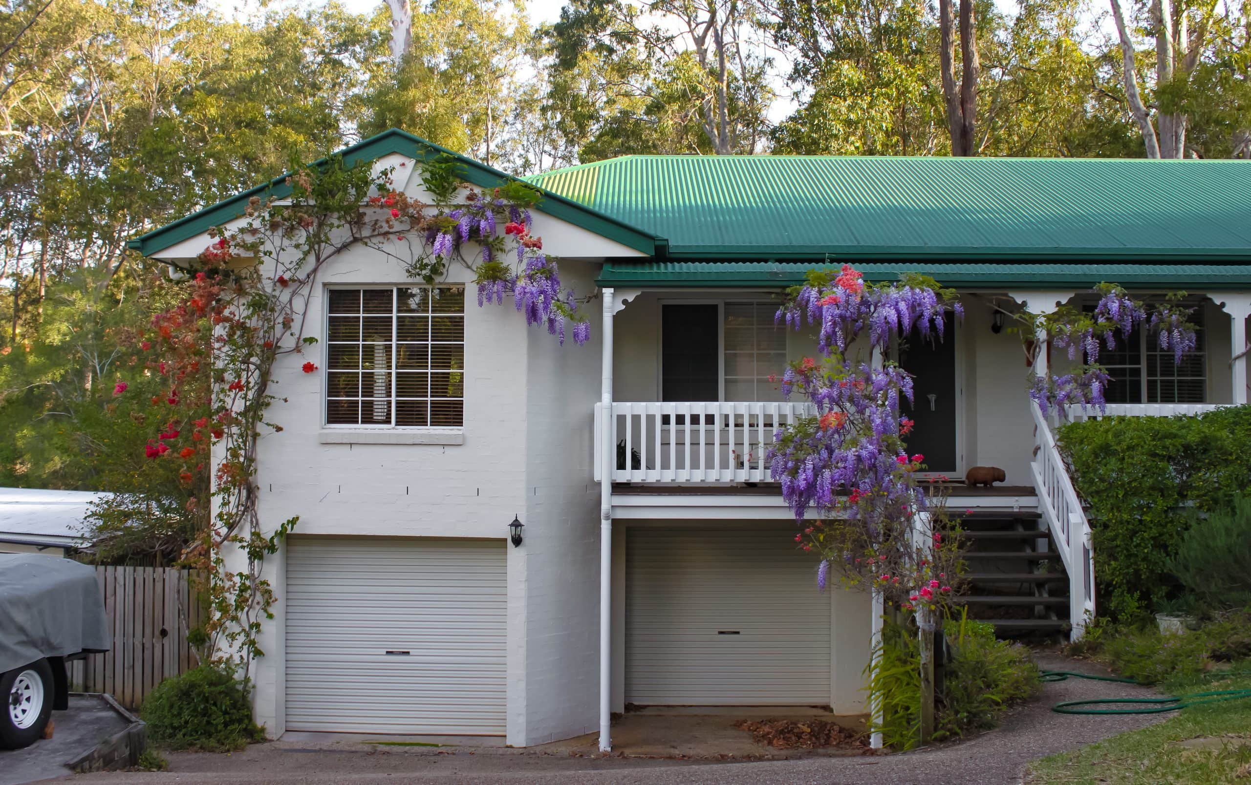 Turbulent times and property settlements. Accompanying picture: Suburban house near Brisbane Australia with wisteria growing over the stairs and porch and tall gum trees behind
