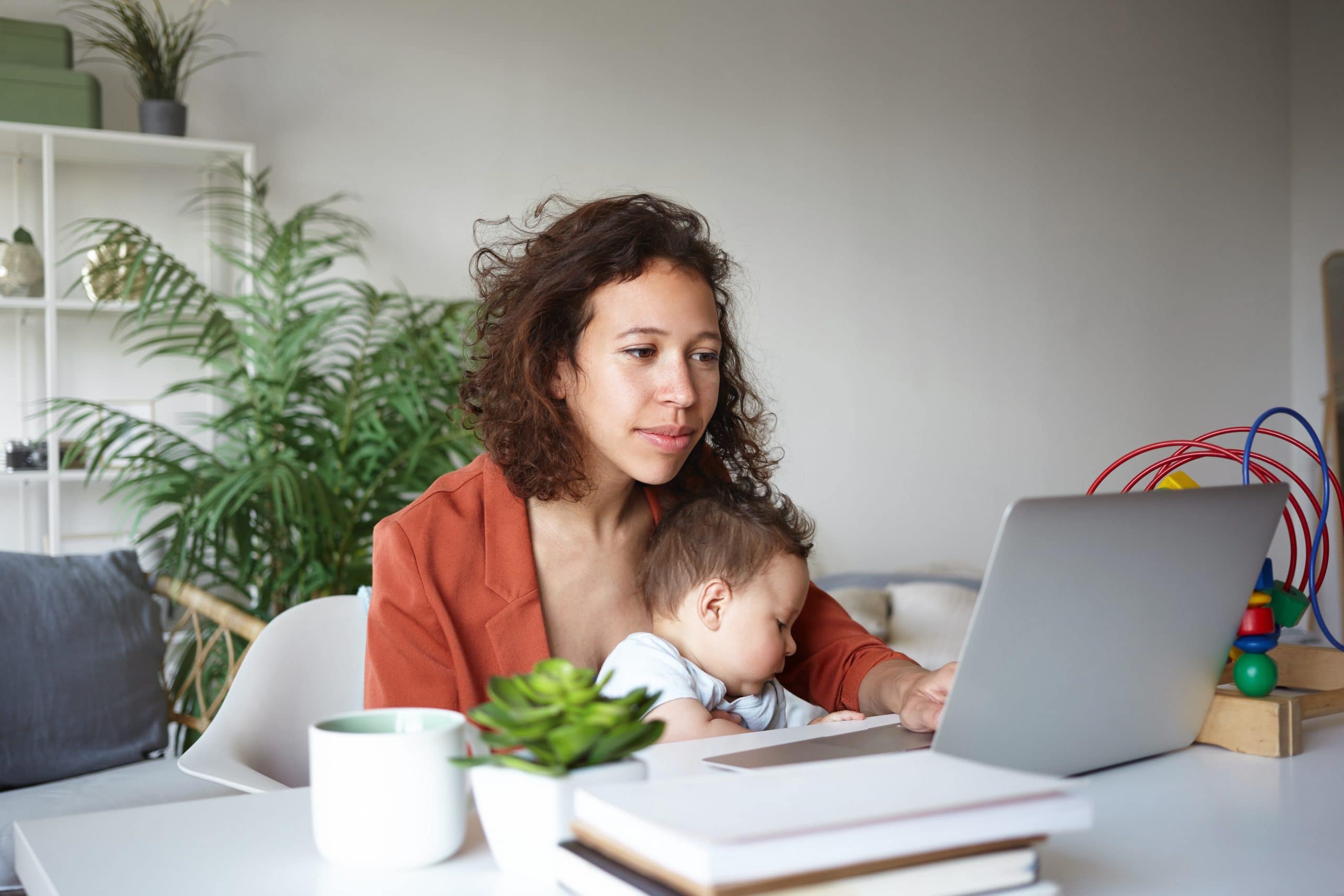 COVID-19 helpful tips if you are separated. Accompanying image: single mother nursing baby and looking for job online