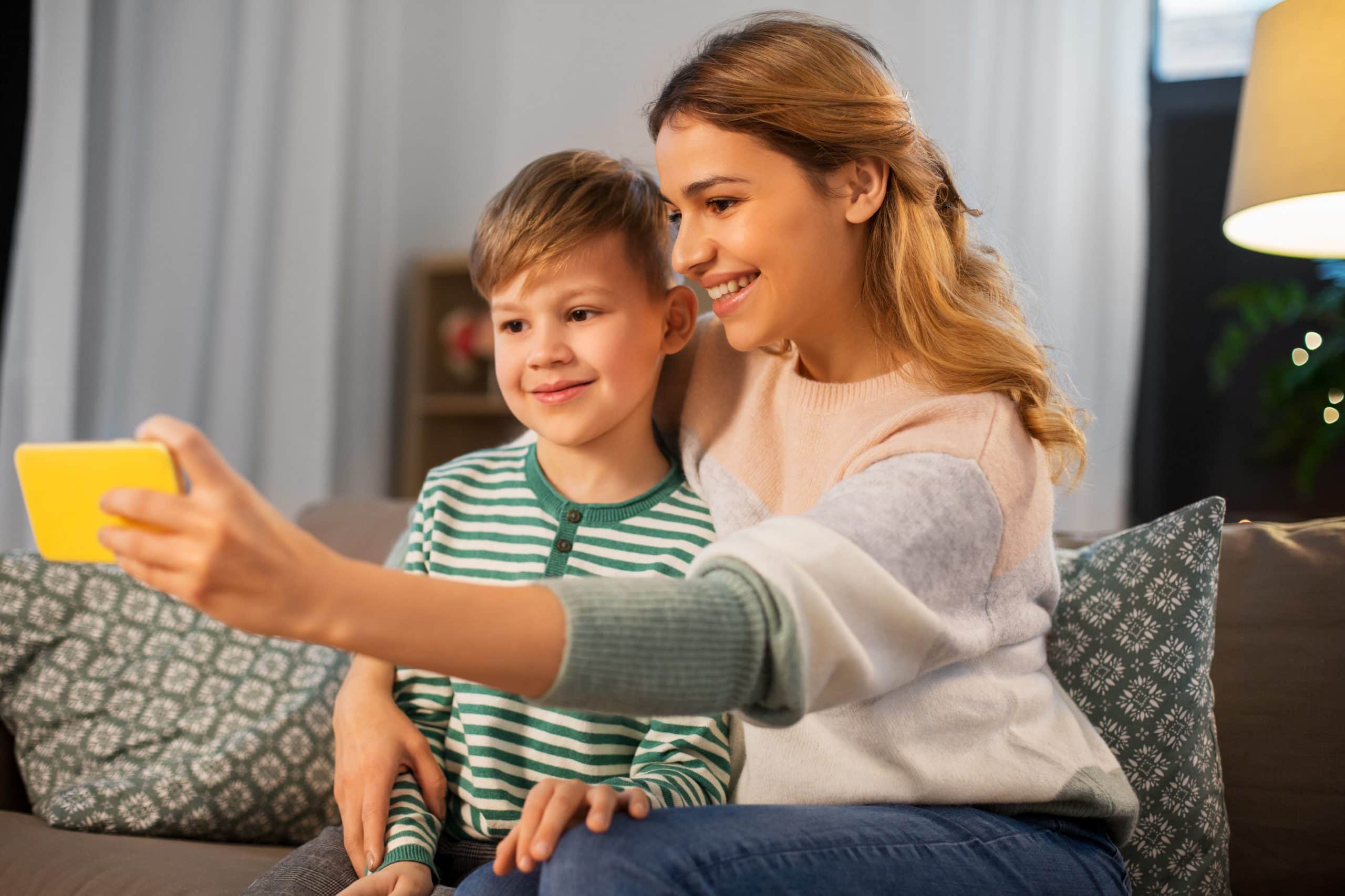 COVID-19 and Parenting Arrangements. Accompanying picture: mother and son taking selfie by smartphone at home