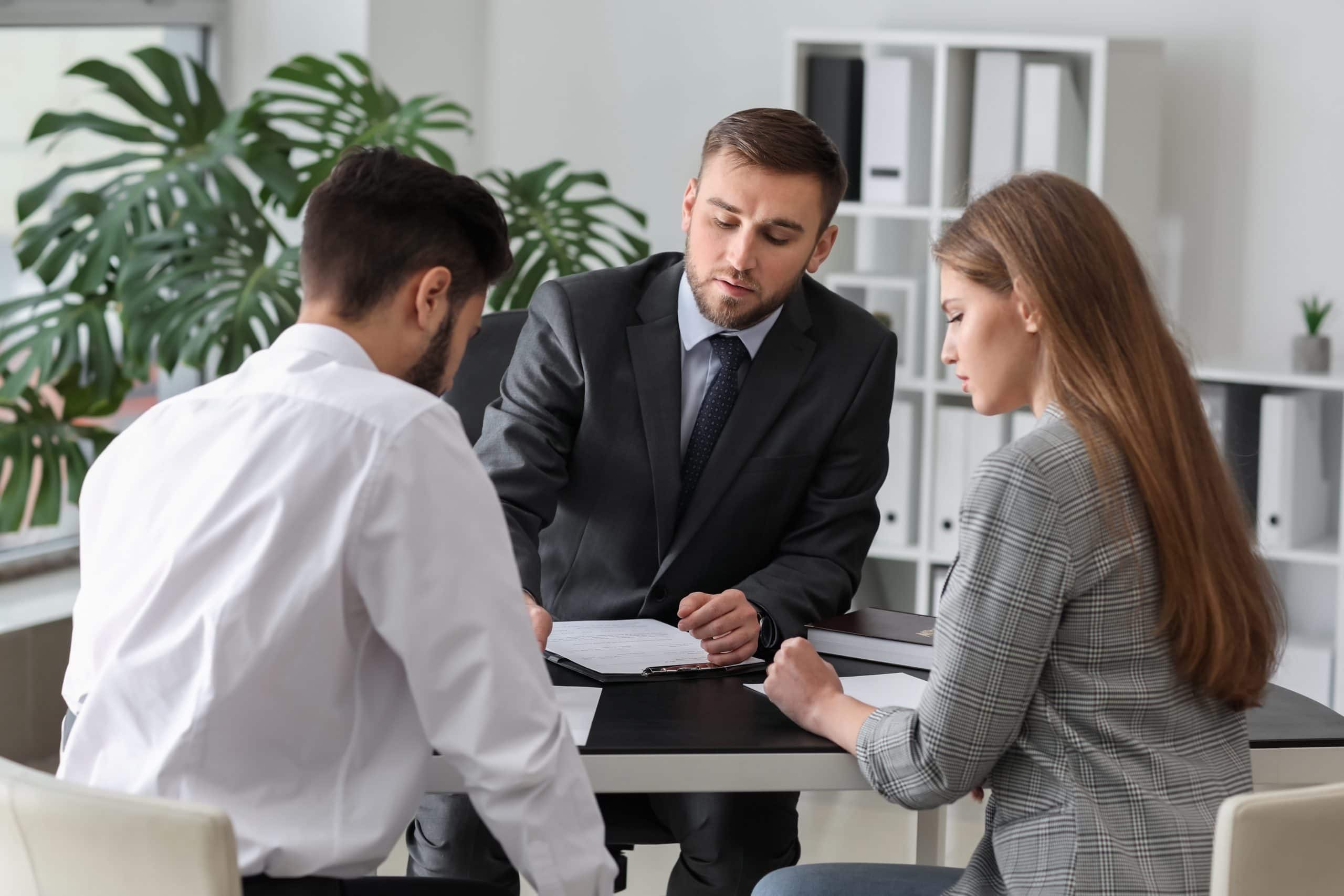 Unhappy young couple visiting divorce lawyer in office