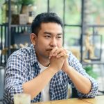 Defacto issues. Accompanying image: a man sitting and thinking in cafe