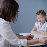 How a Family Report can help your children. Accompanying picture: communication session of school psychologist and girl child