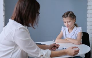 How a Family Report can help your children. Accompanying picture: communication session of school psychologist and girl child