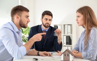 How an injunction can protect your property. Accompanying picture: unhappy couple dividing marital property in office of divorce lawyer