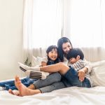 Setting aside a binding child support agreement. Accompanying image: mother, son and daughter sit on bed with happiness and smile in bedroom.