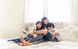 Setting aside a binding child support agreement. Accompanying image: mother, son and daughter sit on bed with happiness and smile in bedroom.