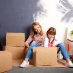Image of mother and daughter packing boxes, accompanying family law article "Relocating after divorce – can I take my child with me?"