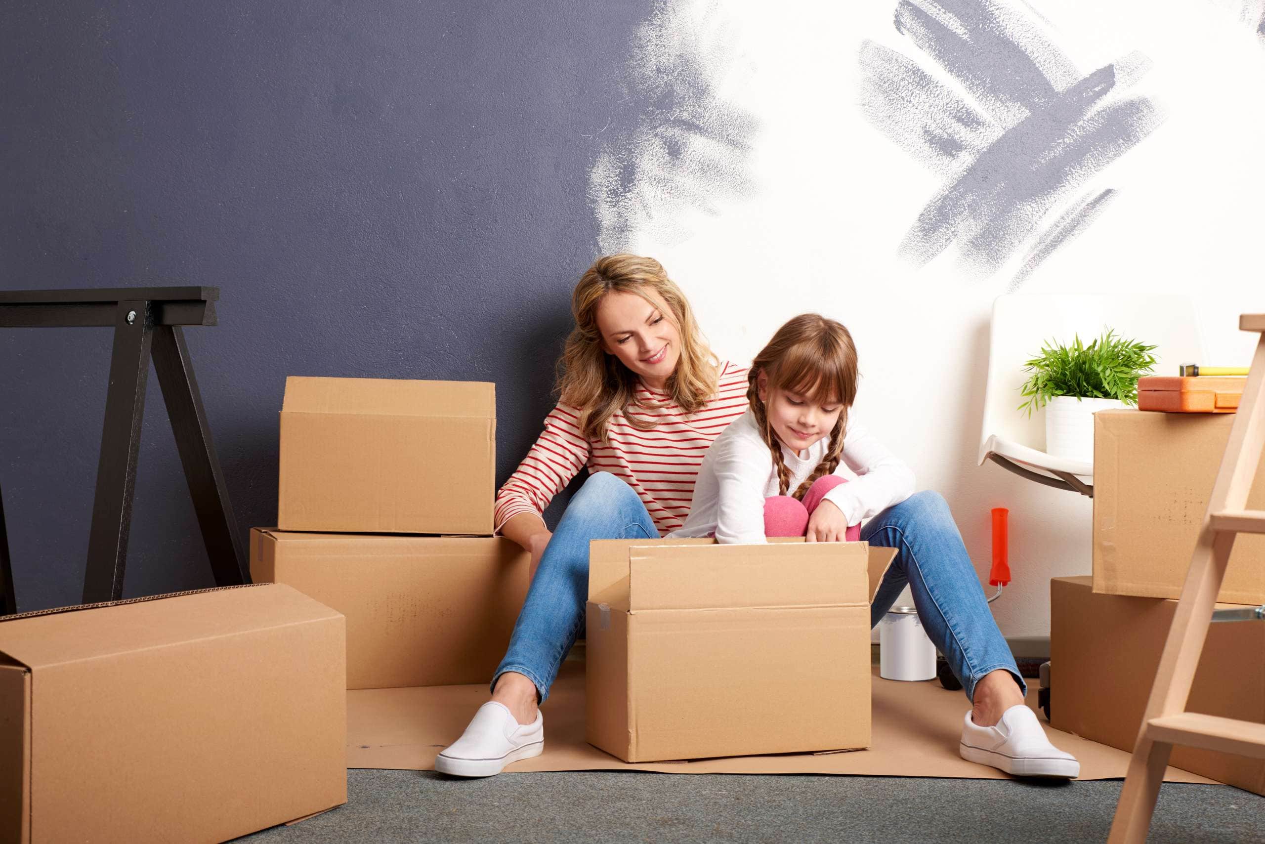 Image of mother and daughter packing boxes, accompanying family law article "Relocating after divorce – can I take my child with me?"
