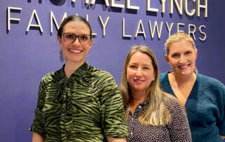 Photo of Susan Miranda, Zoe Adams and Stephanie Brown in front of the Michael Lynch Family Lawyers sign
