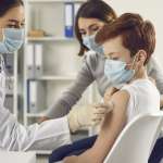 Image of a doctor preparing to vaccinate a child, accompanying family law article "Vaccinations for Children"