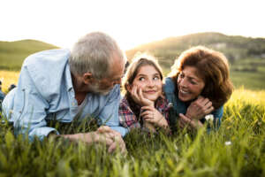 Image of a senior couple with granddaughter outside accompanying family law article "Grandparents, babysitting, and property settlements"