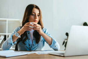 portrait of concentrated businesswoman with cup of coffee at wor Image of a woman with cup of coffee