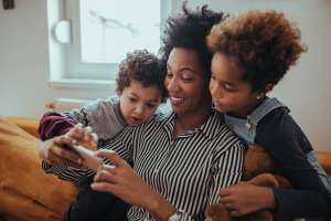 Image of a happy mother with children, accompanying family law article "Keeping the Lines of Communication Open"